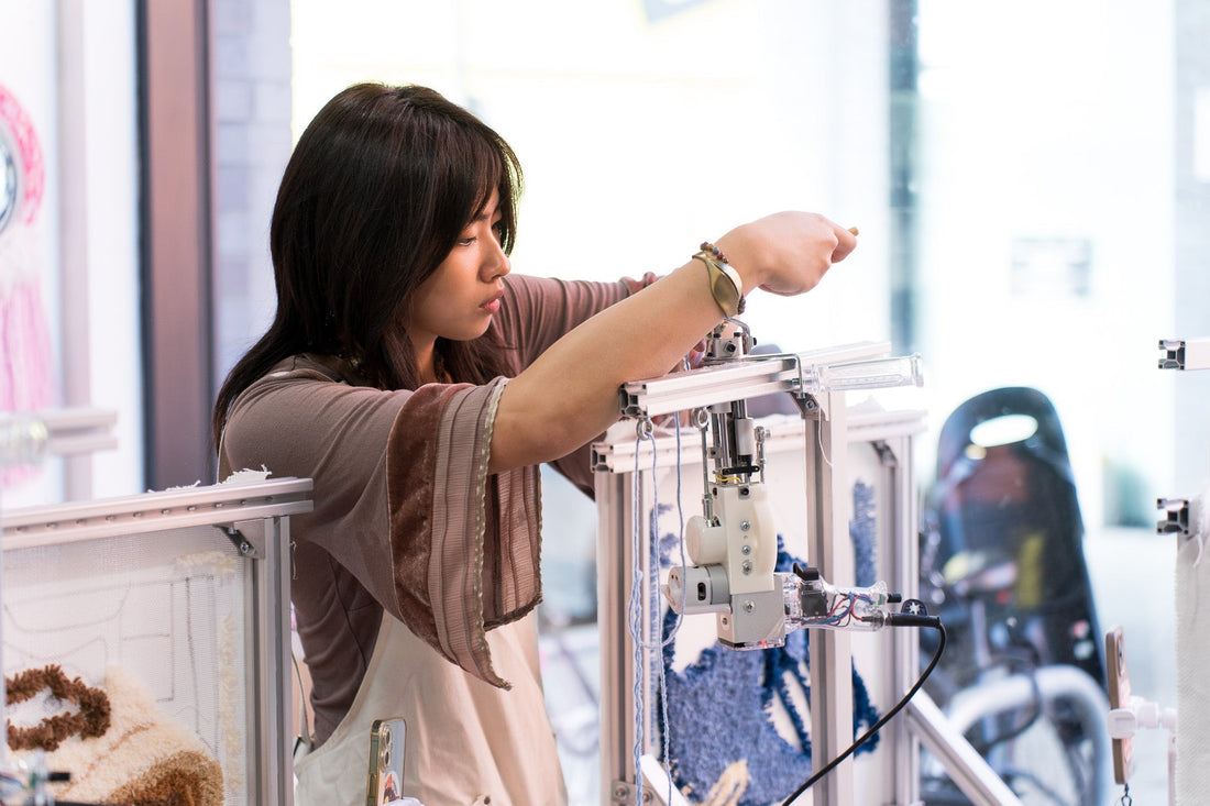 Hands threading yarn through an AK-V tufting gun needle — step-by-step guide by UK Tufting