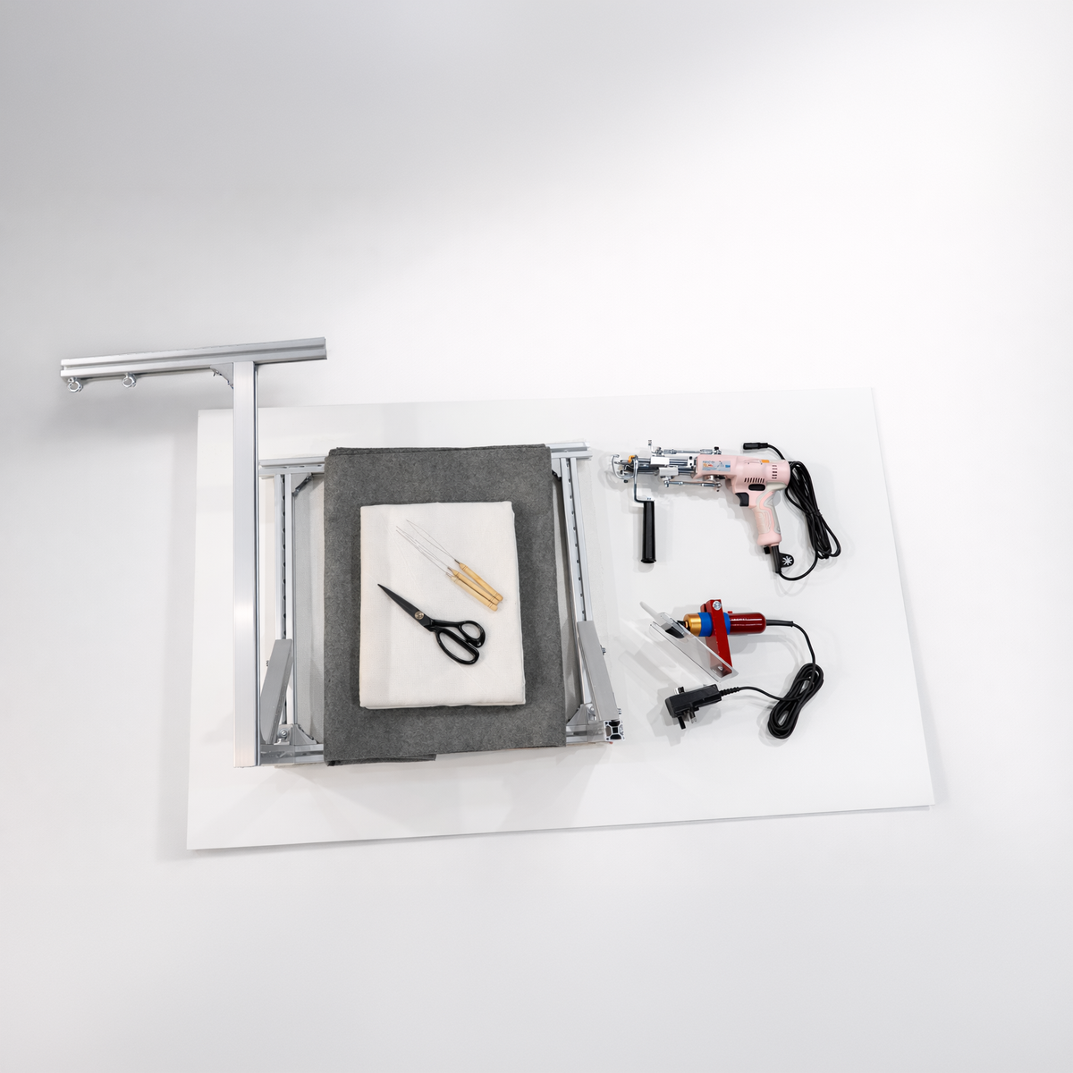 Beginner rug tufting starter kit laid out flat — tufting gun, frame, fabric and tools by UK Tufting