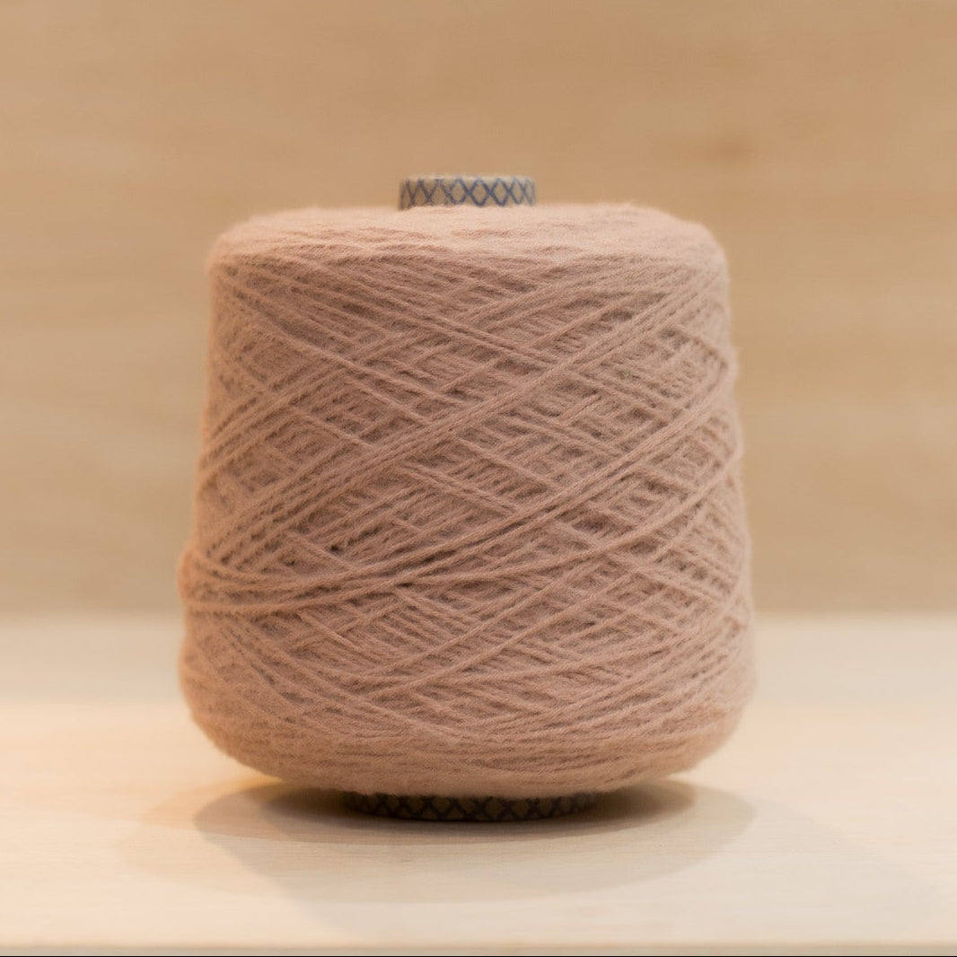 Cheekyarn Loop 8 yarn cone in Dusty Valentine, a muted warm rose-pink, against a natural wood background