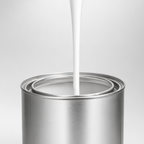 White paint being poured into a silver paint can on a light gray background