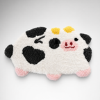 Handmade cow rug tufted with Loop 8 001 Asphalt recycled polyester yarn, showing soft black yarn details and a playful animal design
