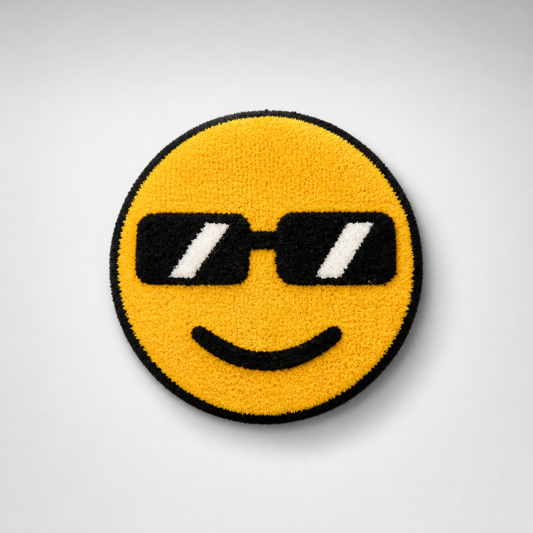 Handmade tufted emoji rug with black sunglasses and a smiley face on a soft yellow background